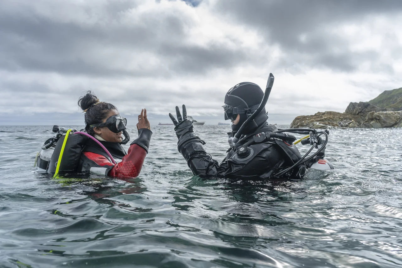 A PADI professional and a new diver signal at the surface.