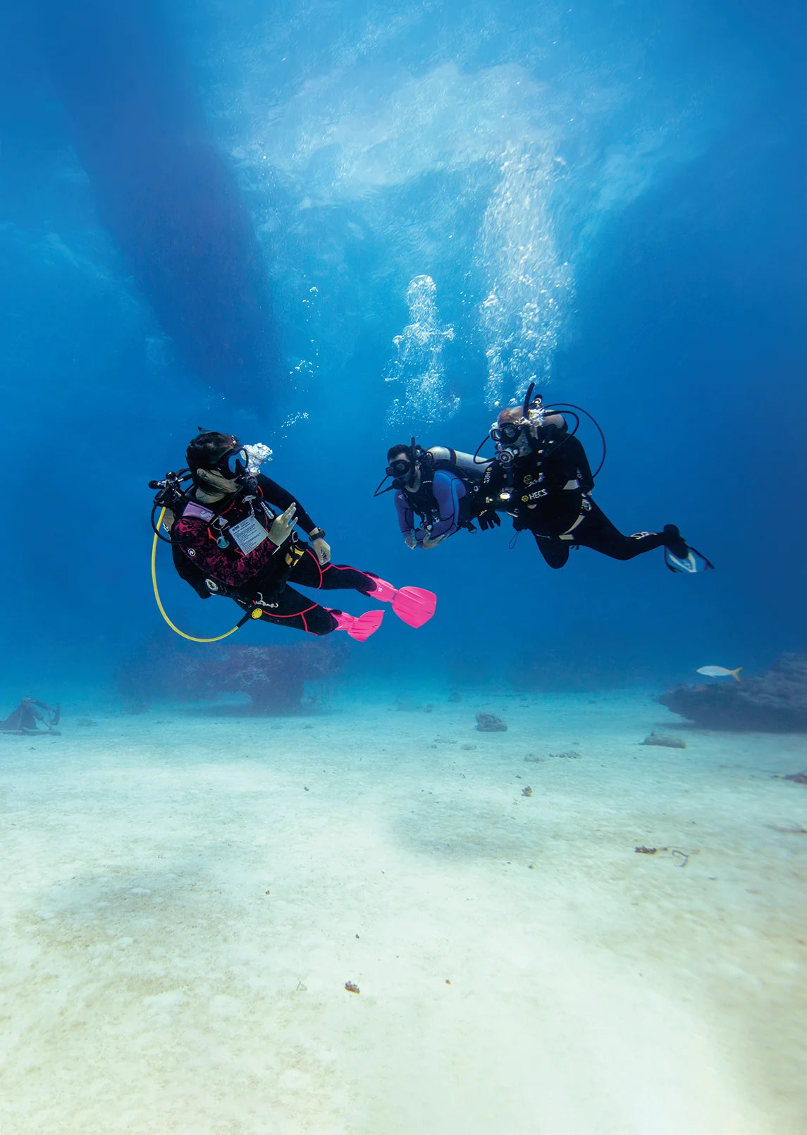 An instructor demonstrates buoyancy with a diver in Open Water Scuba Instructor imagery.