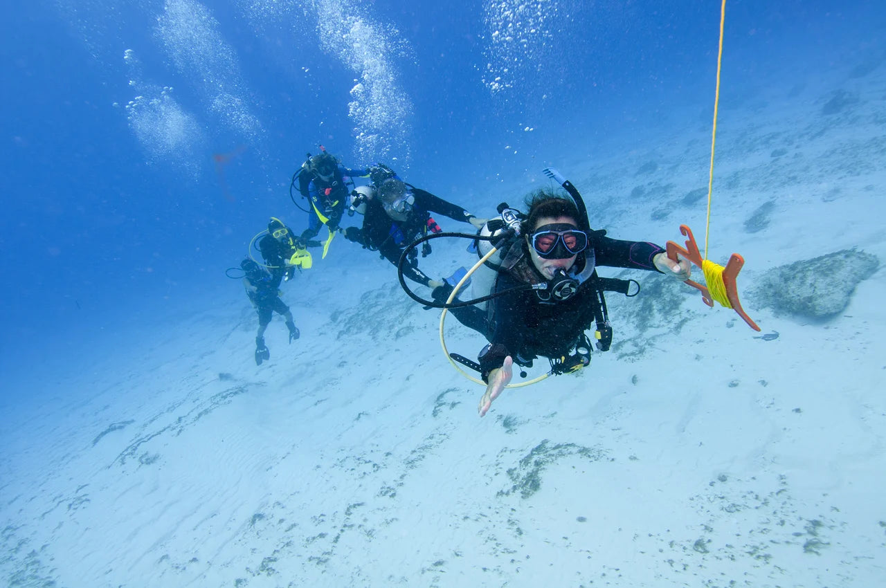 Divers move through the water with a surface-marker buoy in PADI Drift Diver imagery.