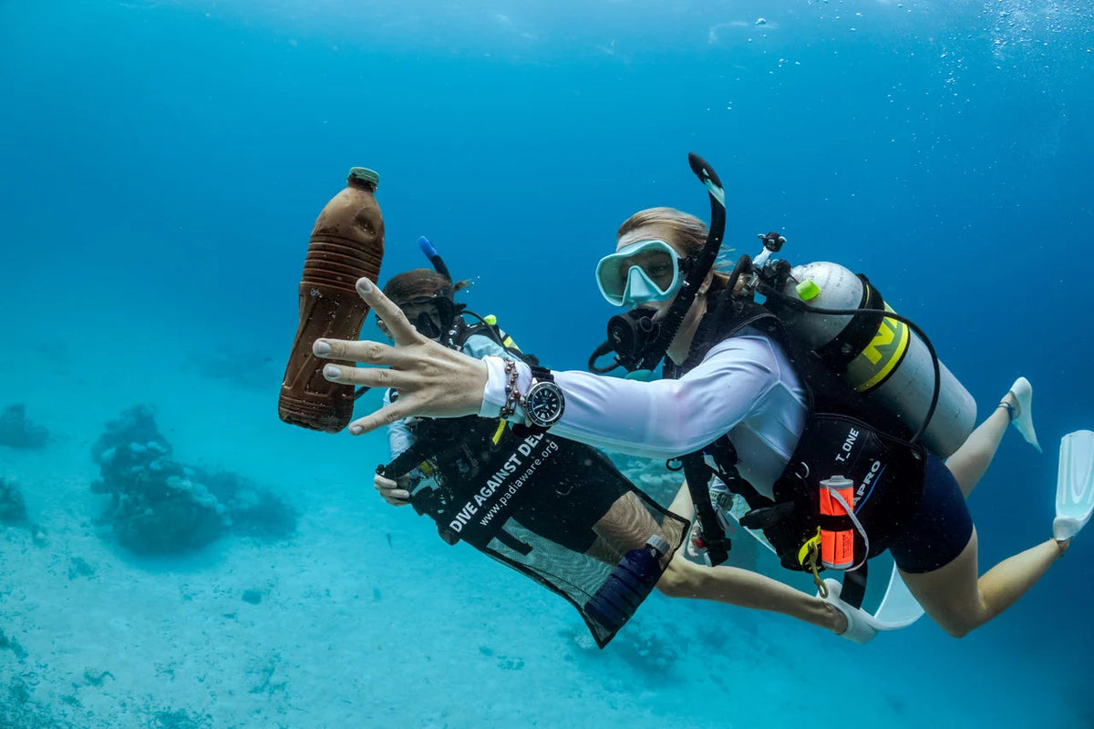 A diver collects discarded bottles in Dive Against Debris program imagery. © PADI 2026