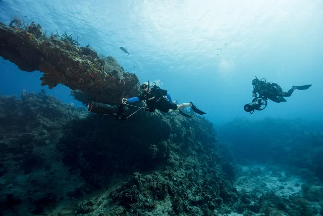 Divers using underwater scooters in PADI Diver Propulsion Vehicle training imagery.