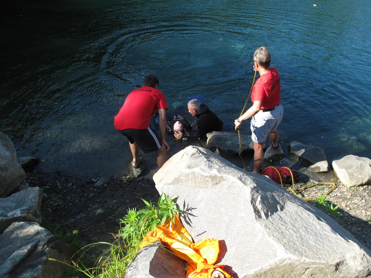 A public-safety dive team works at the shoreline.